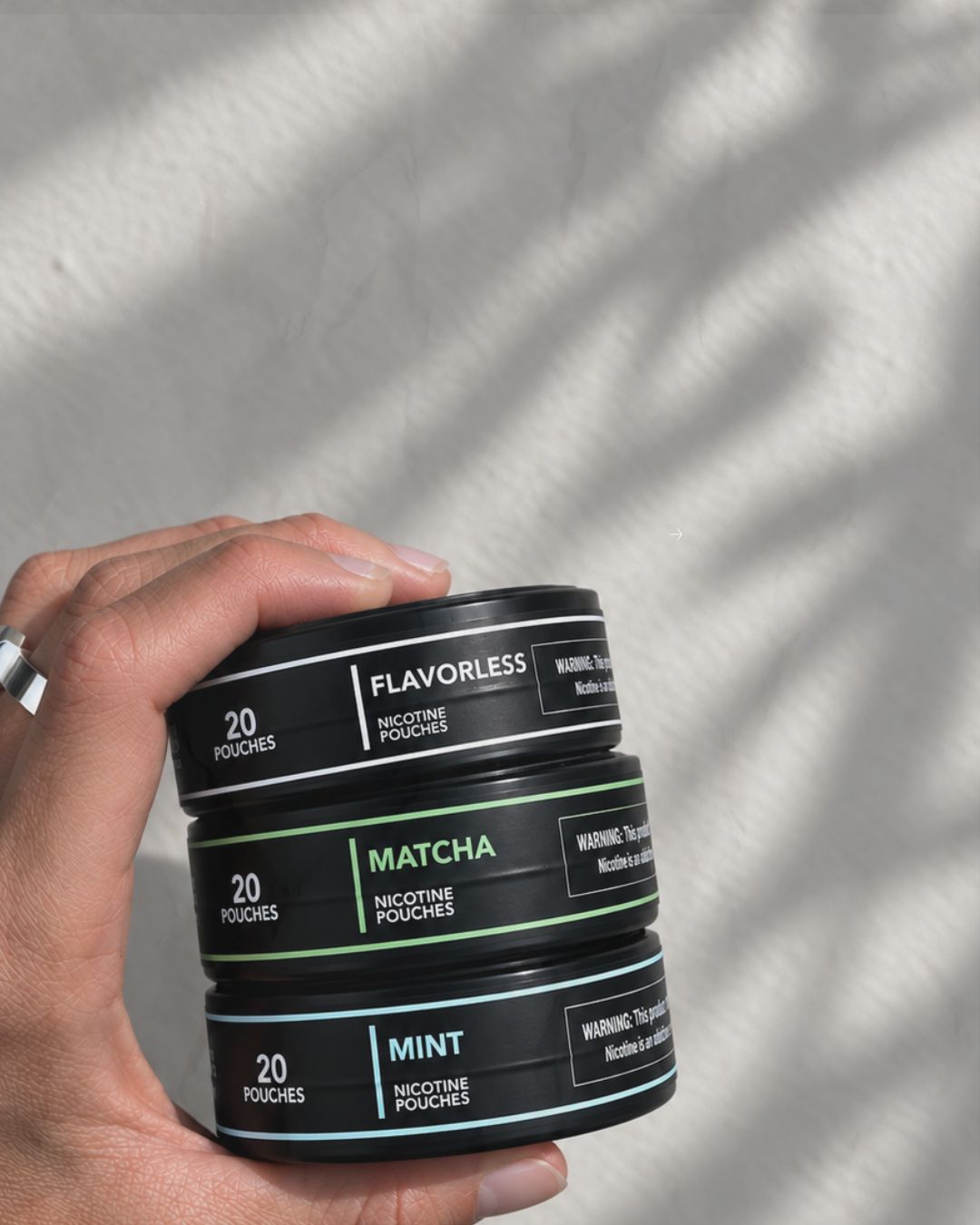 Flavorless, Matcha and Mint cans stacked in one hand